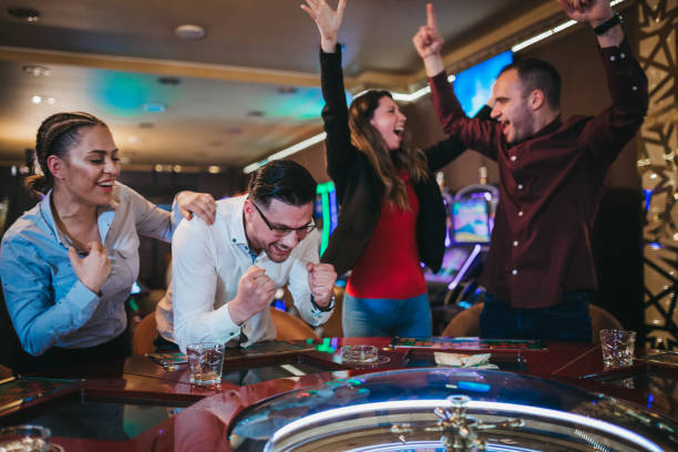 Cheerful group of friends enjoys winning poker roulette in a casino